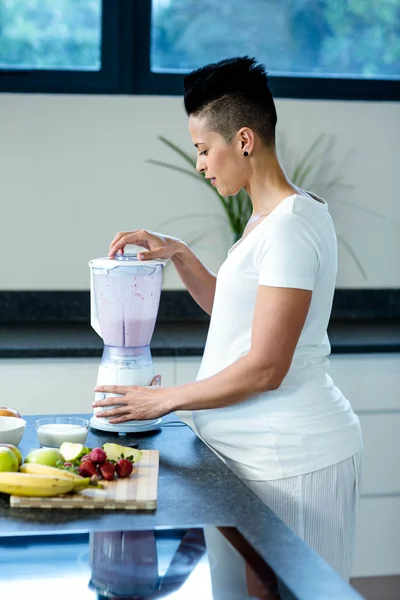 Gravid kvinna förbereder fruktjuice — Stockfoto