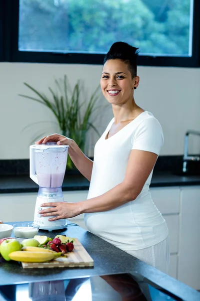 Těhotná žena, příprava ovocné šťávy — Stock fotografie