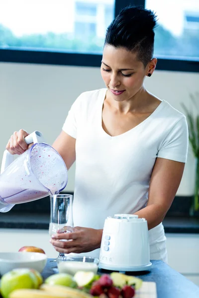 Pregnant woman pouring smoothie in glass — Stock Photo, Image