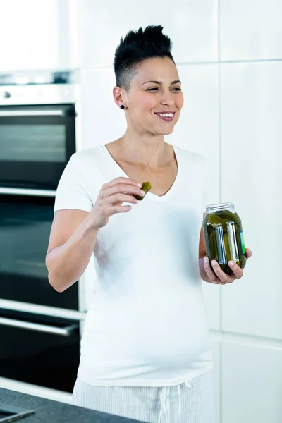 Těhotná žena jíst okurky — Stock fotografie