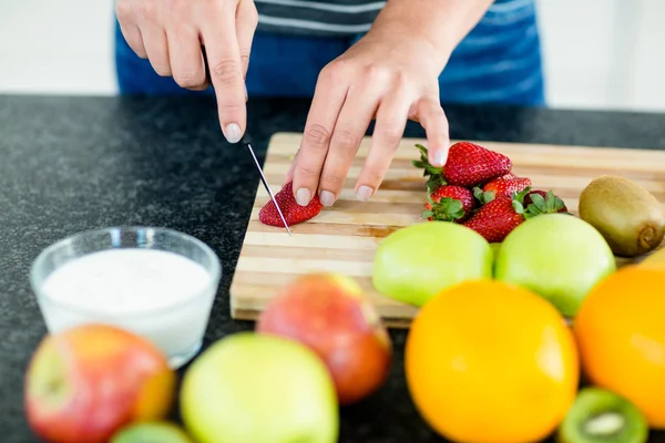Donna che taglia frutta sul tagliere — Foto Stock