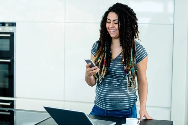 Woman standing near worktop with phone — Stock Photo, Image