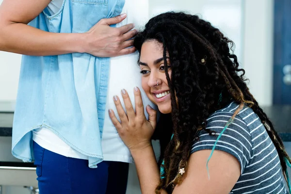 Жінка слухає вагітних партнерів шлунок — стокове фото
