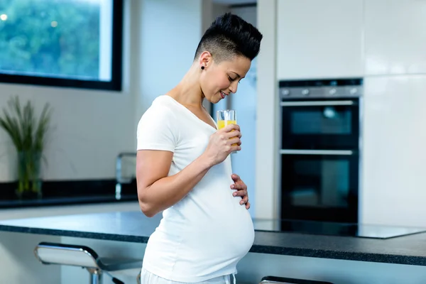 Těhotná žena pití šťávy — Stock fotografie