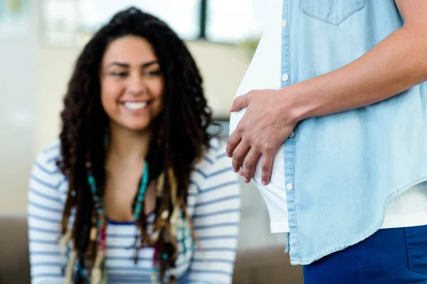 Mulher olhando para sua barriga parceiros grávidas — Fotografia de Stock