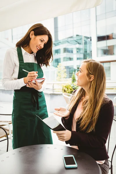 Leende servitris tar en beställning — Stockfoto