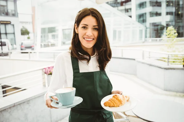 Servírka pózuje s kávou a croissantem — Stock fotografie