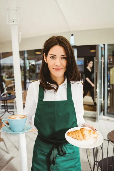 Servitrisen poserar med kaffe och croissant — Stockfoto