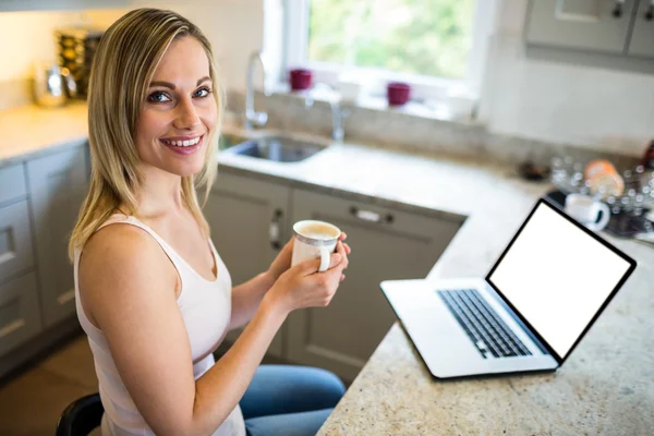 Žena s kávou a za použití notebooku — Stock fotografie