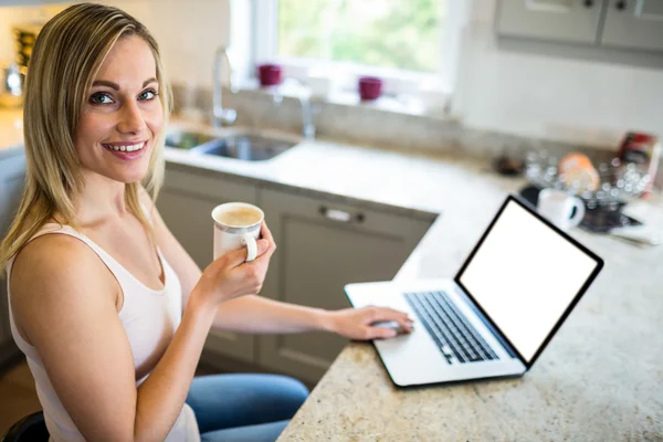 Mulher tomando café e usando laptop — Fotografia de Stock