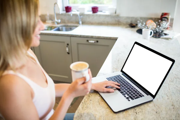 Kvinna med kaffe och använder bärbar dator — Stockfoto