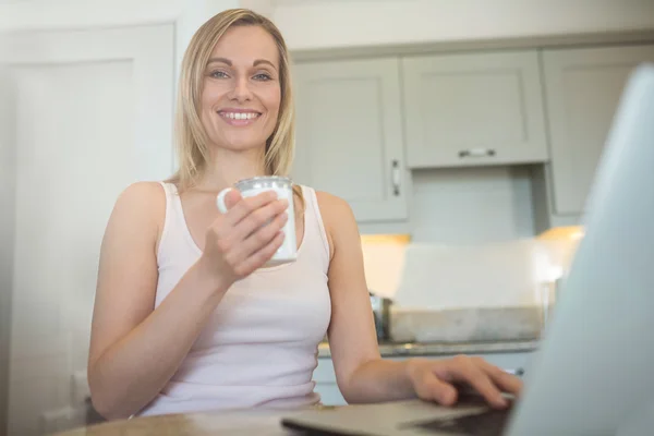 Mujer tomando café y usando laptop —  Fotos de Stock