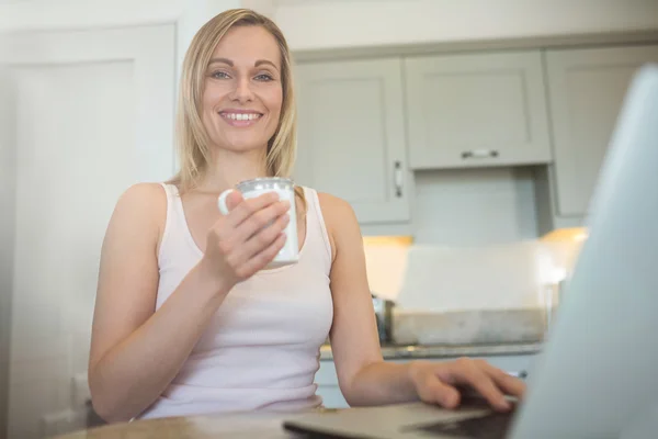 Mulher tomando café e usando laptop — Fotografia de Stock