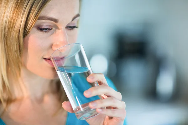 Blond kvinna dricka glas vatten — Stockfoto