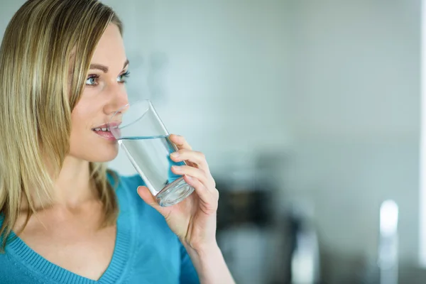 Blonde vrouw glas water te drinken — Stockfoto