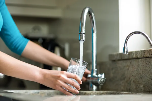 Vrouw vullen glas water — Stockfoto