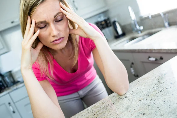 Unavený blonďatá žena s migrénou — Stock fotografie