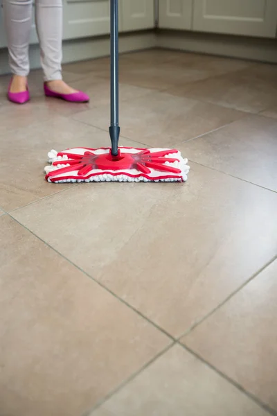 Mulher deslizando chão da cozinha — Fotografia de Stock