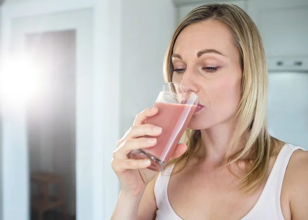 Vrouw met haar zelfgemaakte smoothie — Stockfoto