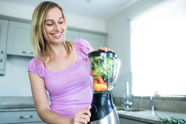 Mulher loira preparando smoothie — Fotografia de Stock