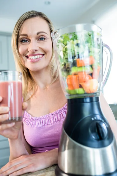 Mujer bebiendo batido en la cocina —  Fotos de Stock