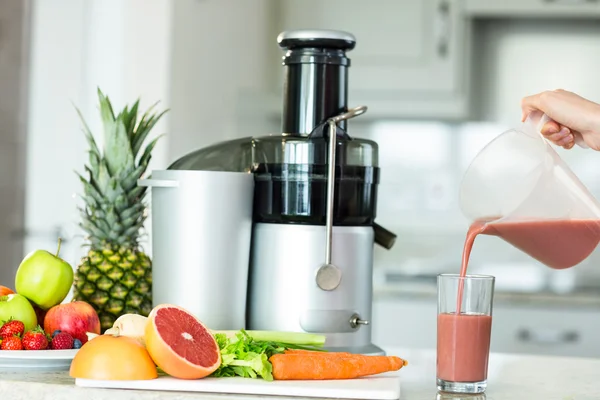 Woman pouring smoothie in glass — Stock Photo, Image