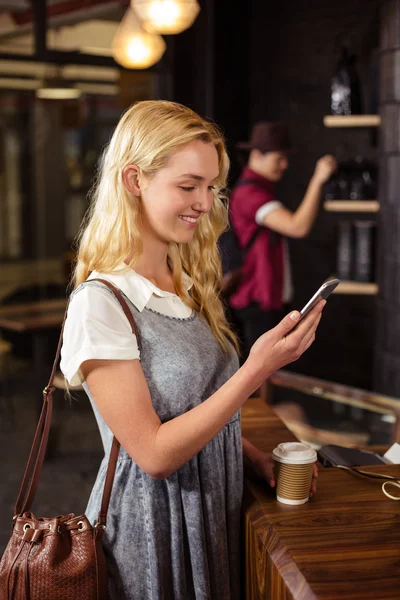 Blondýnka pití kávy a pomocí smartphone — Stock fotografie