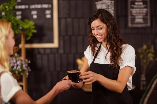 Camarera que ofrece una taza de café al cliente — Foto de Stock
