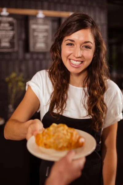 Serveuse donnant croissant au client — Photo