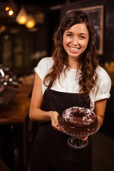 Garçonete apresentando bolo de chocolate — Fotografia de Stock