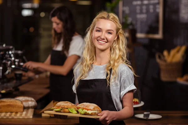 Serveerster bedrijf dienblad met sandwiches — Stockfoto