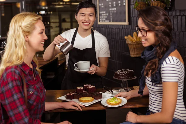 Amici sorridenti godendo pasticcini — Foto Stock