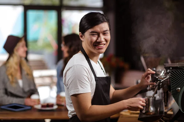 Camarero sonriente haciendo una taza de café — Foto de Stock