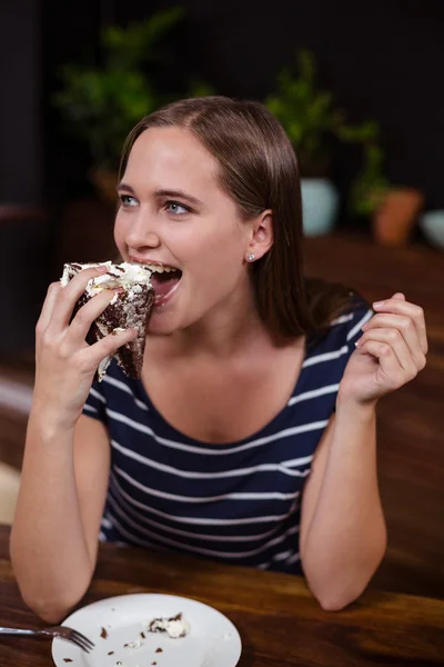 Frau isst Stück Kuchen mit der Hand — Stockfoto