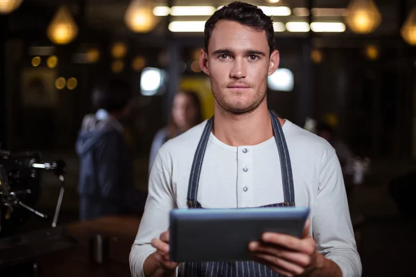 Barista κρατώντας tablet και εξετάζοντας τη φωτογραφική μηχανή — Φωτογραφία Αρχείου