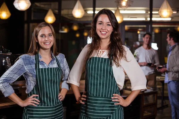 Baristaer som står med hendene på hoftene – stockfoto