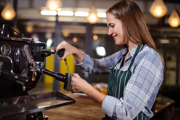 Smiling barista making hot milk with coffee machine — Stock Photo, Image