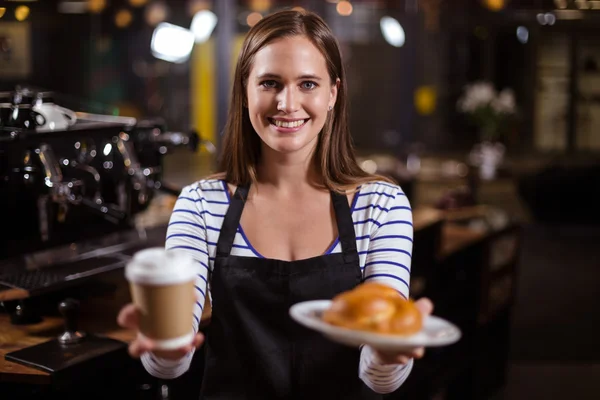 Barista segurando copo descartável e brioche — Fotografia de Stock