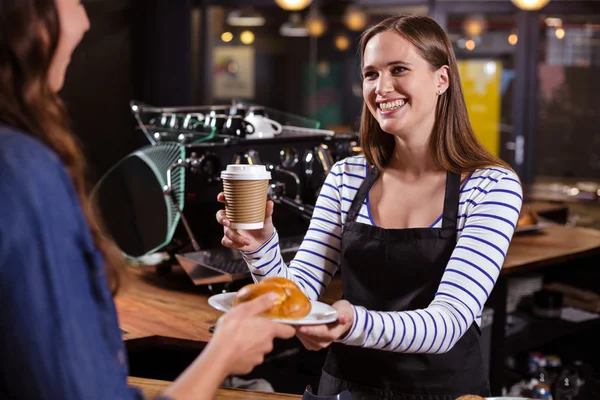 Barista holding disposable beker en brioche — Stockfoto