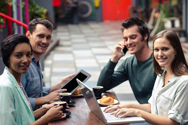 Vrienden bij bar met behulp van technologie — Stockfoto