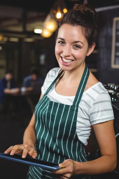 Smilende barista ved hjælp af tablet - Stock-foto