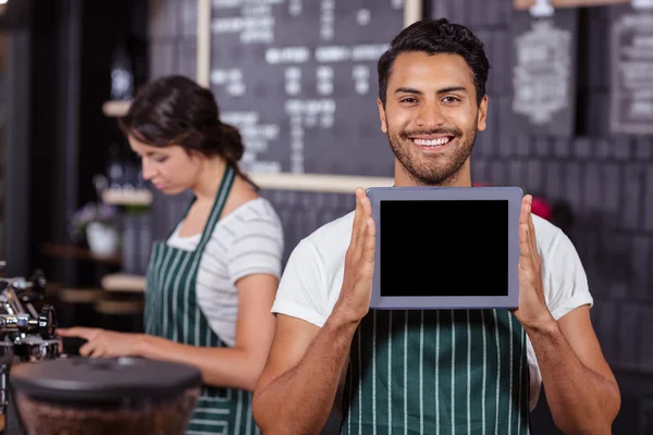 Barista sonriente mostrando tableta — Foto de Stock