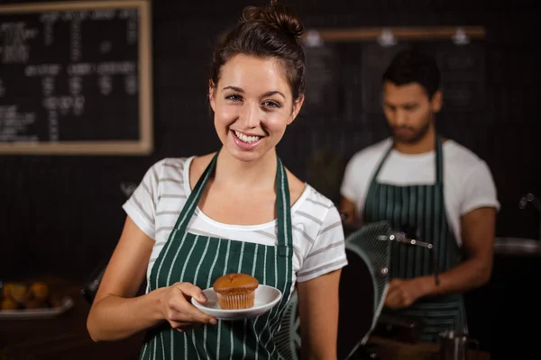 Χαμογελώντας barista κρατώντας muffin — Φωτογραφία Αρχείου