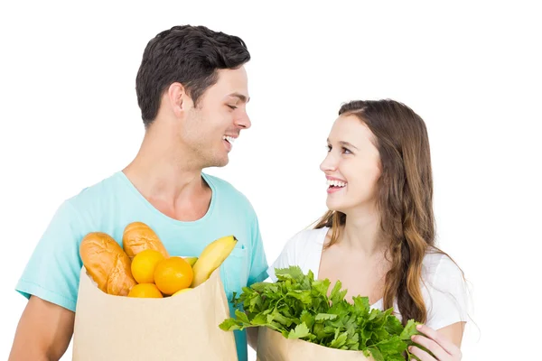 Pareja feliz llevando bolsas de comestibles — Foto de Stock