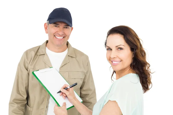 Kvinnliga kunden registrerar på papper med leverans mannen — Stockfoto