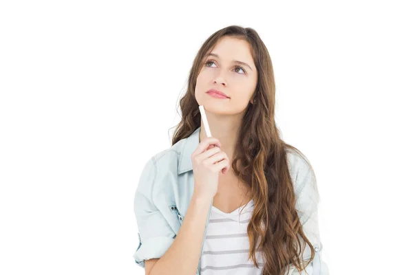 Estudiante pensativa sosteniendo una tiza — Foto de Stock