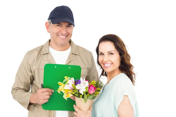 Vrouwelijke klant ondertekening op papier met levering man — Stockfoto