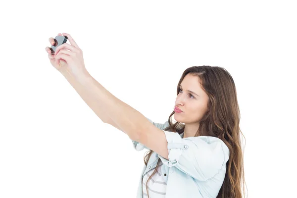 Mujer joven sonriente tomando una selfie mientras hace muecas — Foto de Stock