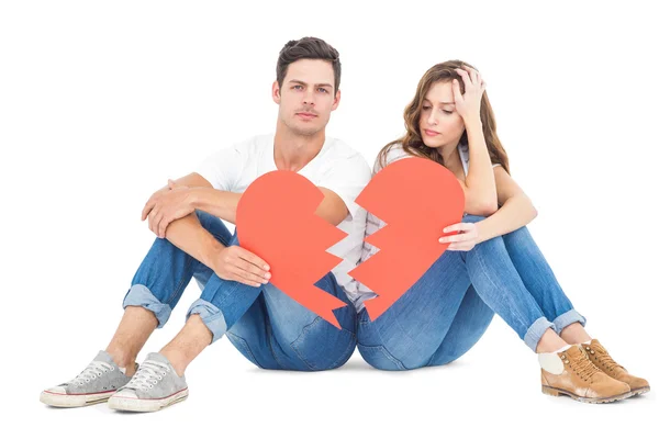 Молода пара сидить на підлозі з розбите серце — стокове фото