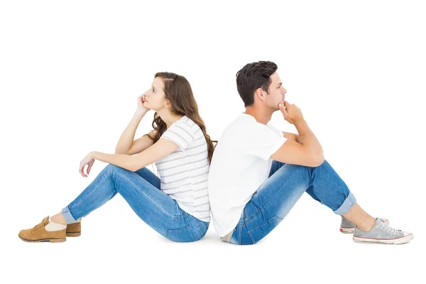 Omtänksamma paret sitter på golvet rygg mot rygg — Stockfoto